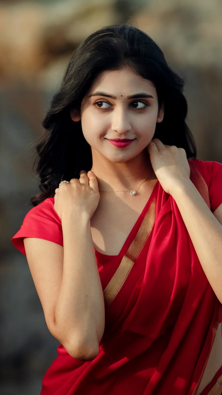 Red Sari Portrait with warm outdoor light, sideways gaze, raised hands, gold sari border, and cinematic natural beauty.