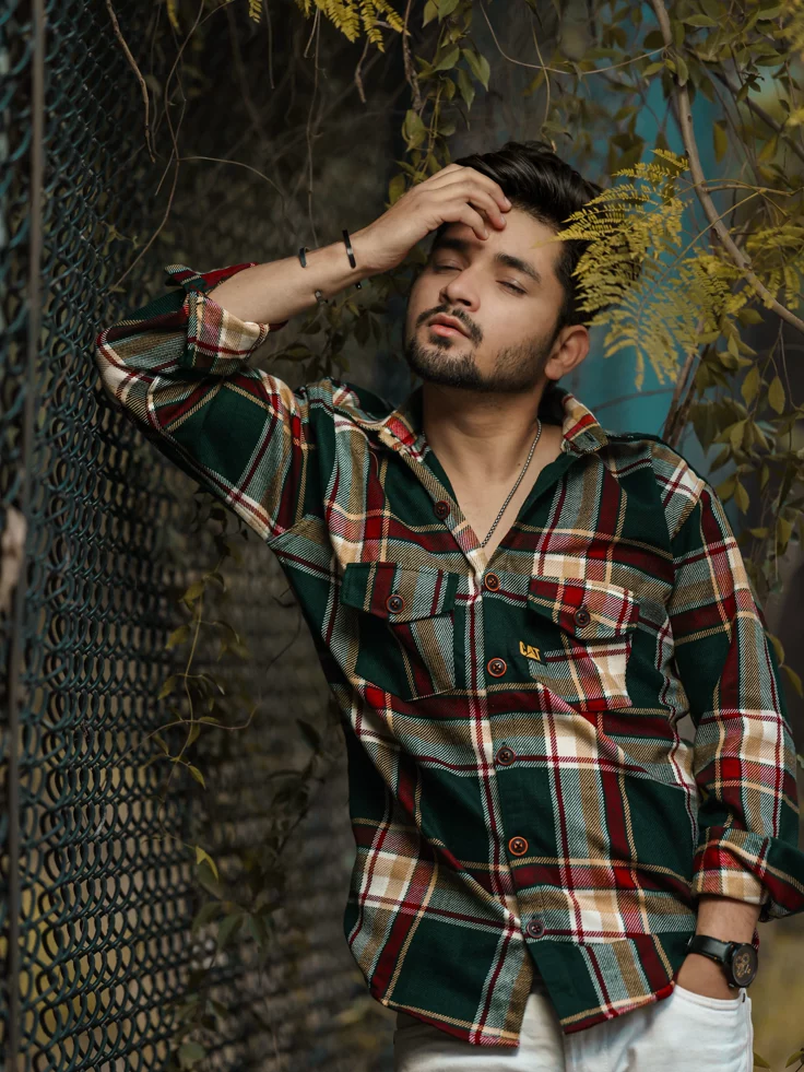 Mens Fashion Portrait Prompt featuring a moody outdoor editorial portrait with plaid shirt styling and cinematic garden lighting